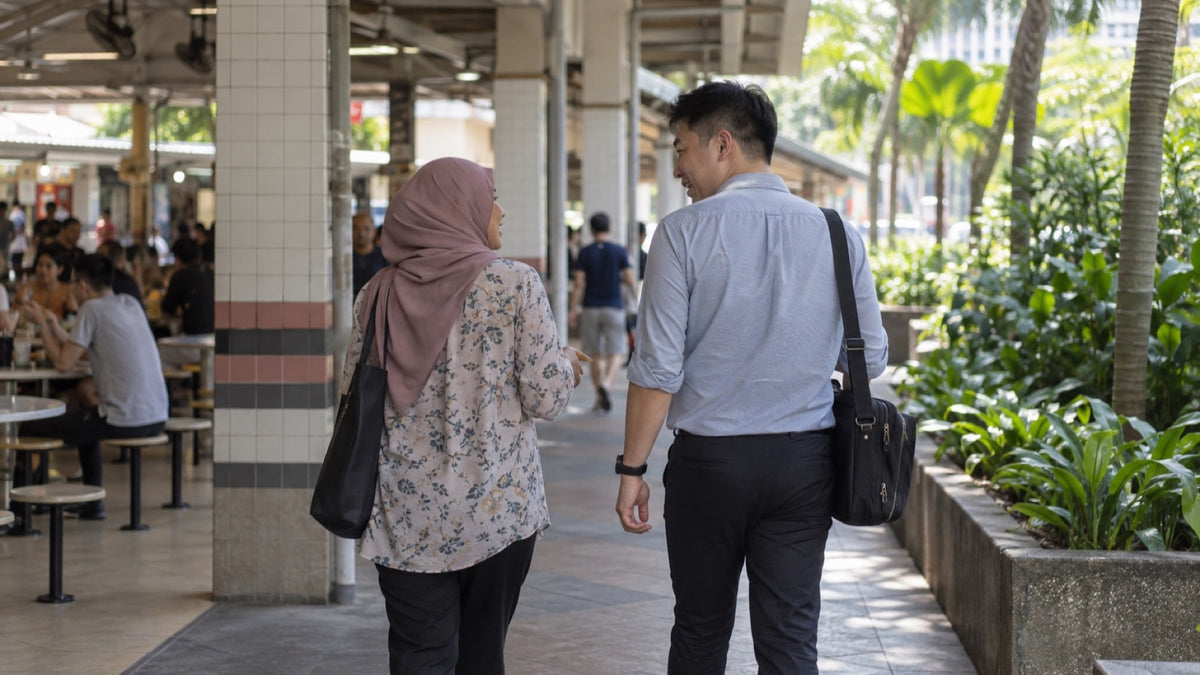 Two adults walking from a hawker-centre edge along a shaded covered walkway.
